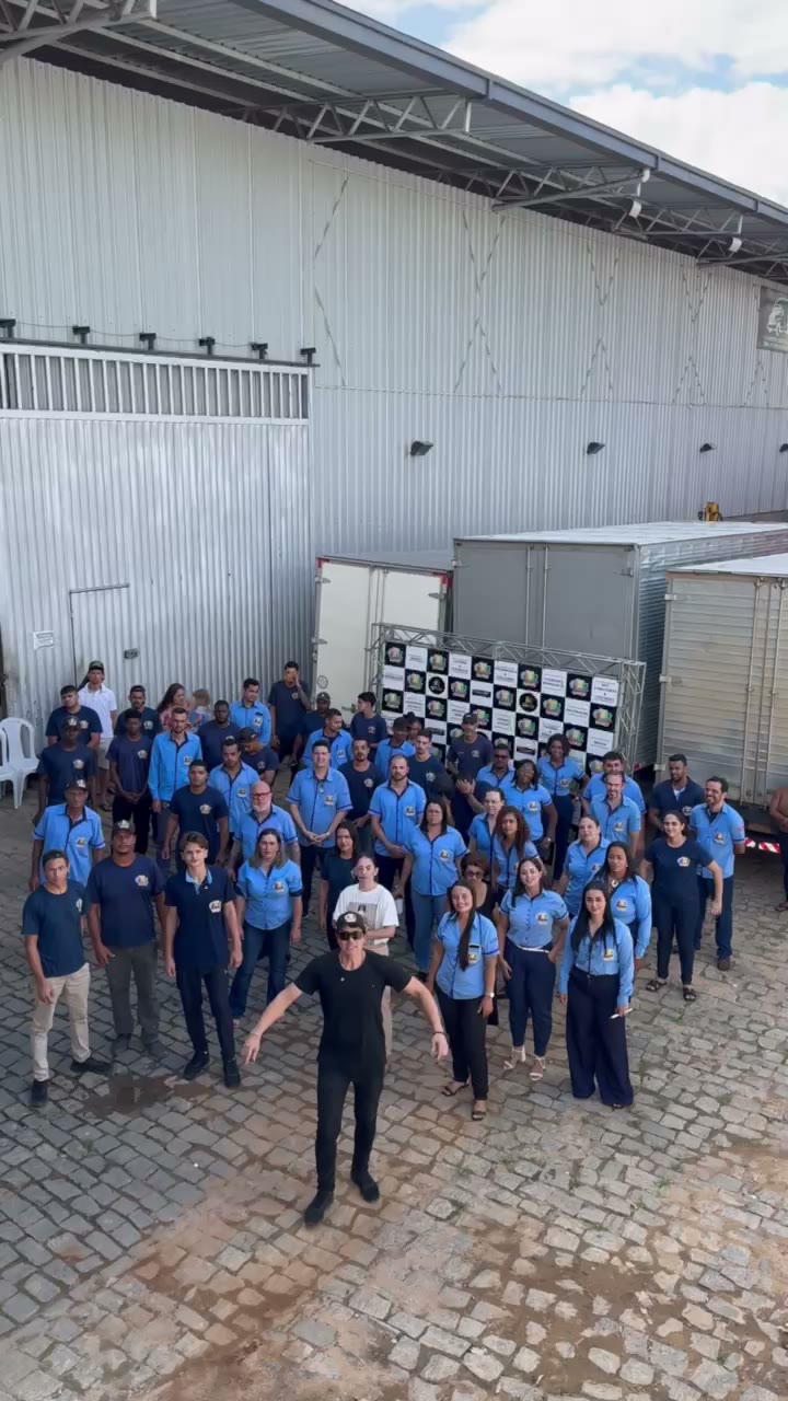 Equipe do Grupo JNF reunida no pátio, ao lado da frota própria de caminhões de entrega