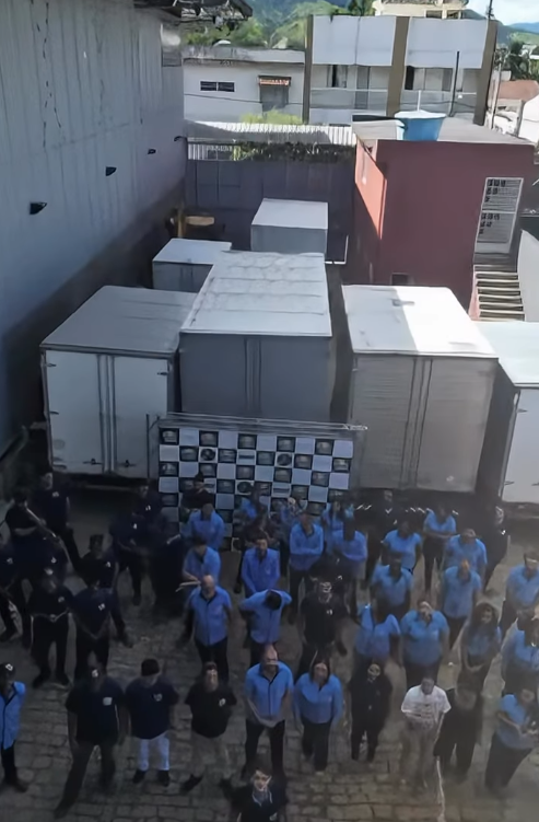 Equipe do Grupo JNF reunida junto à frota de caminhões de entrega